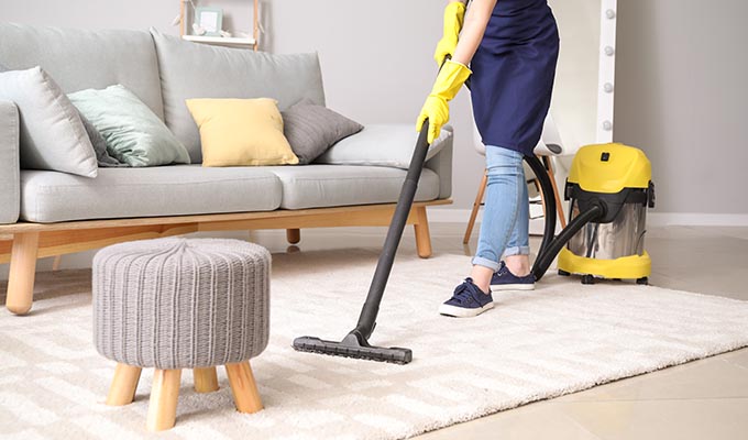 cleaning company in Nottingham, person cleaning a white carpet in a living room.